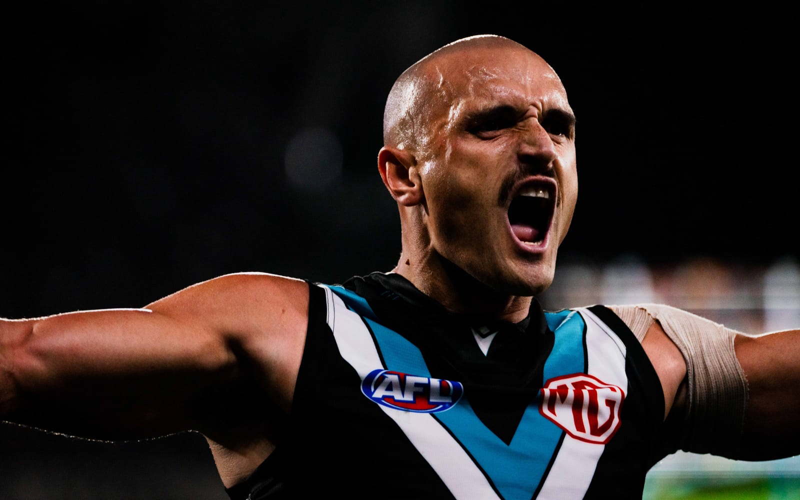 Sam Powell-Pepper roaring with his arms outstretched after kicking a goal.