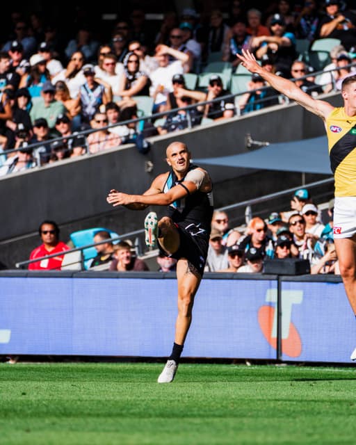 Sam Powell-Pepper kicking the ball in front of a full grandstand.