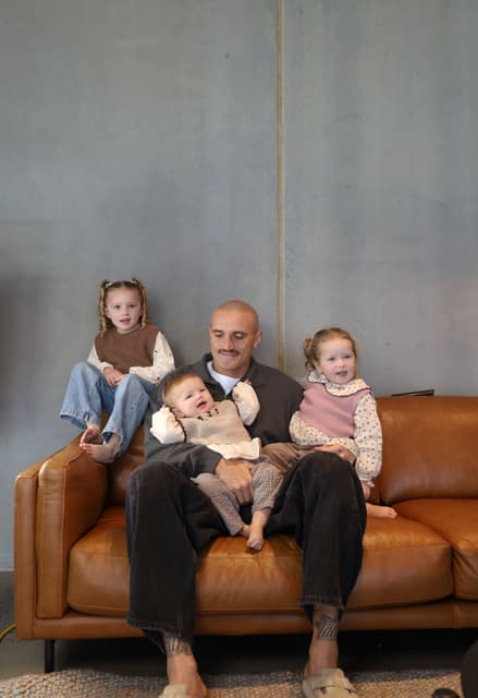 Sam Powell-Pepper on the couch with all three of his daughters.